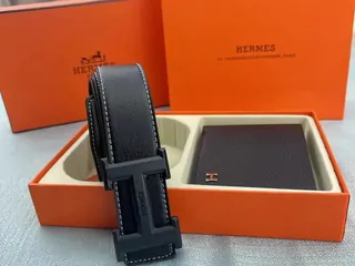A boxed black leather belt with a flat buckle