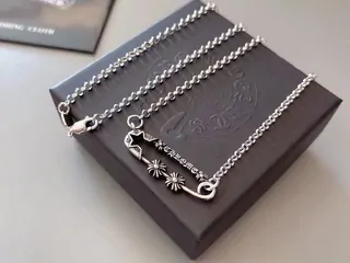 A thin gold chain necklace laid on a dark box