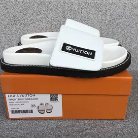 White padded-strap platform sandals on an orange box