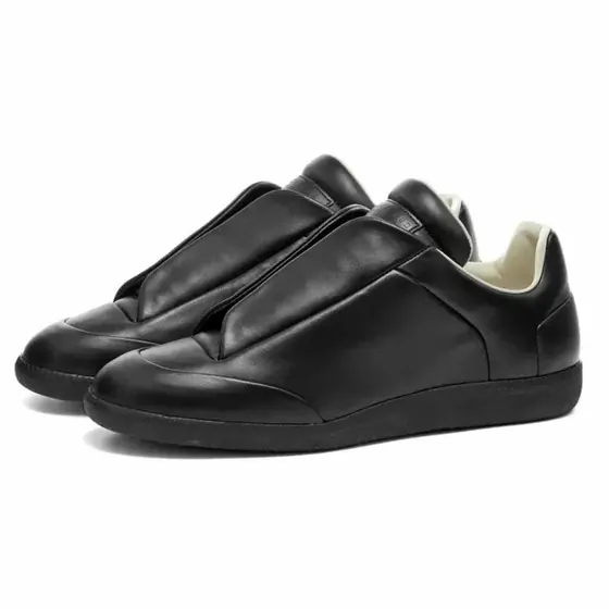 A pair of black leather slip-on trainers with a wide strap