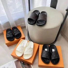 Black and cream padded slides on orange boxes