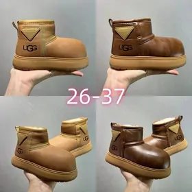 Children's shiny tan and brown mini boots held in a hand