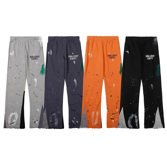 Four paint-splattered track trousers in grey, charcoal, orange and black